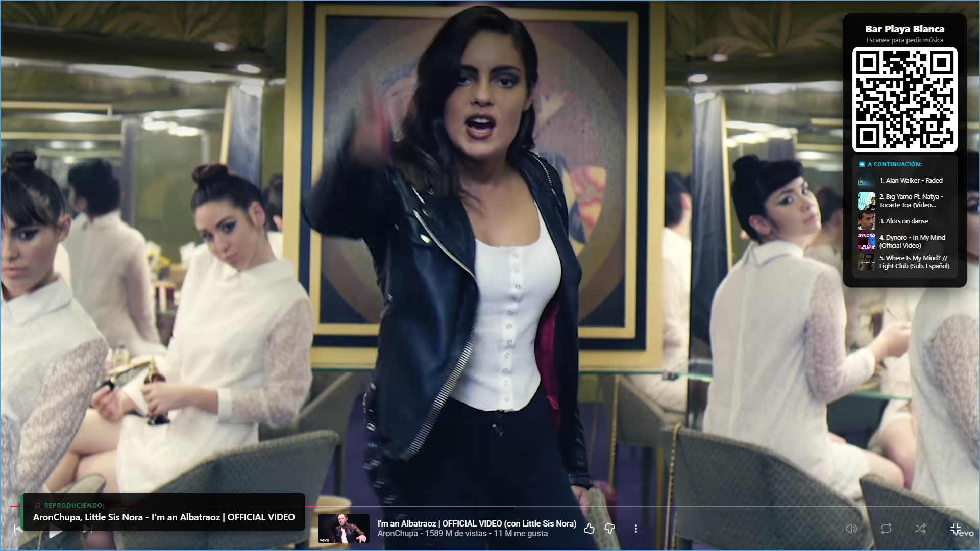Pantalla del televisor: el video a pantalla completa, el código QR para pedir música y la lista de las siguientes canciones