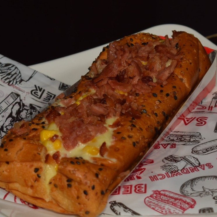 Perro Ranchero (Pan brioche, salchicha, queso doble crema fundido con maíz tierno y tocineta en trozos)