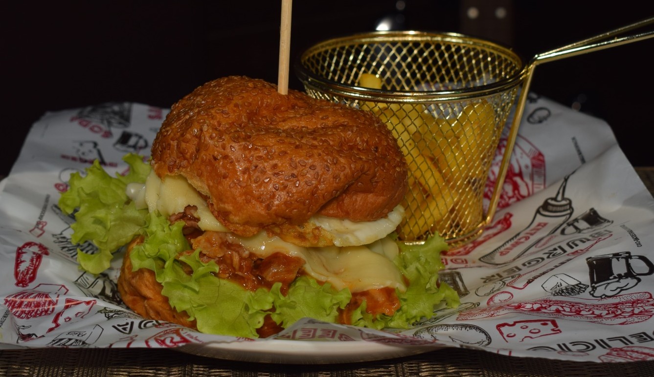 Criolla (Pan Brioche, carne de cerdo desmechada en salsa bbq, queso doble crema, huevo frito, vegetales y porción de papa)