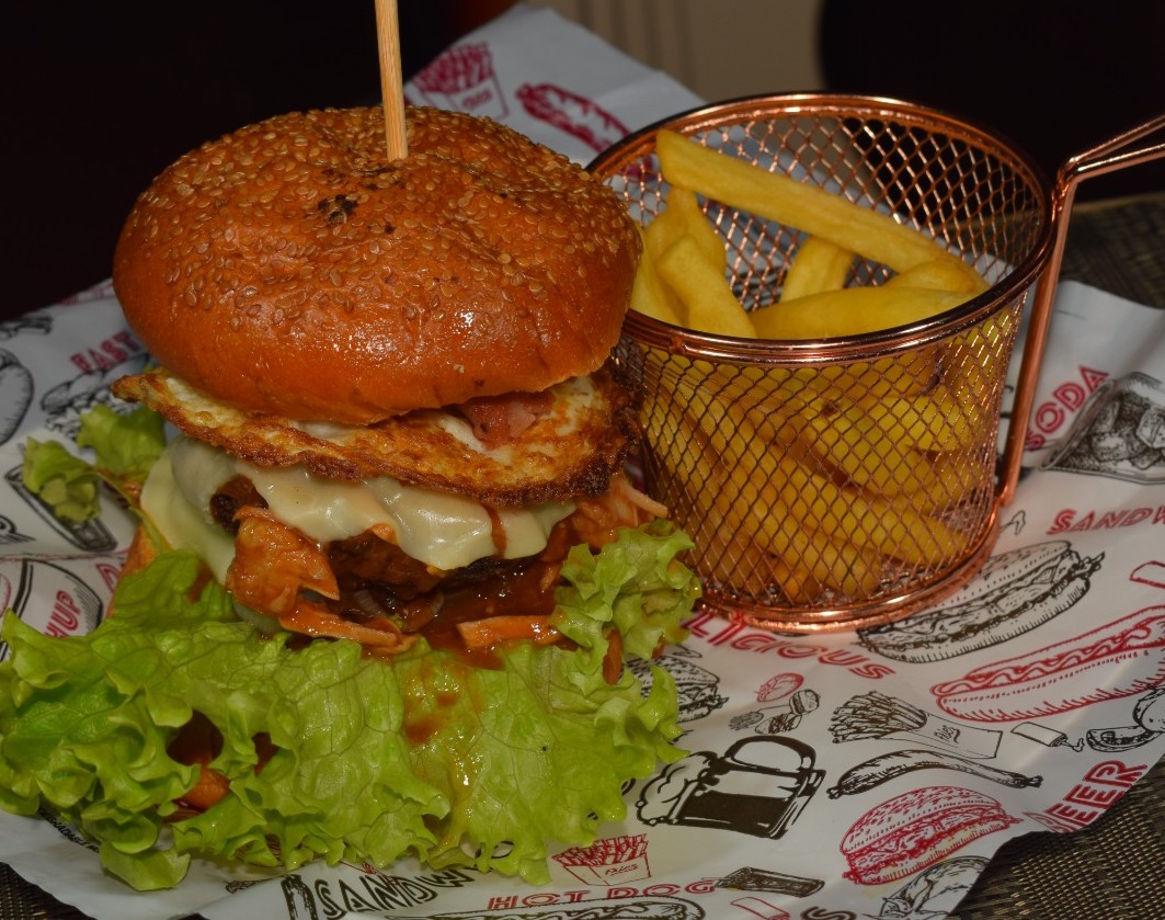 Superlondon (Pan Brioche, carne, carne de cerdo desmechada en salsa bbq, queso doble crema, huevo frito, chorizo, vegetales y porción de papa)